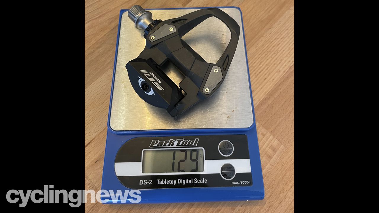 A single Shimano 105 Pedal on a Park Tools scale, showing the weight at 129g
