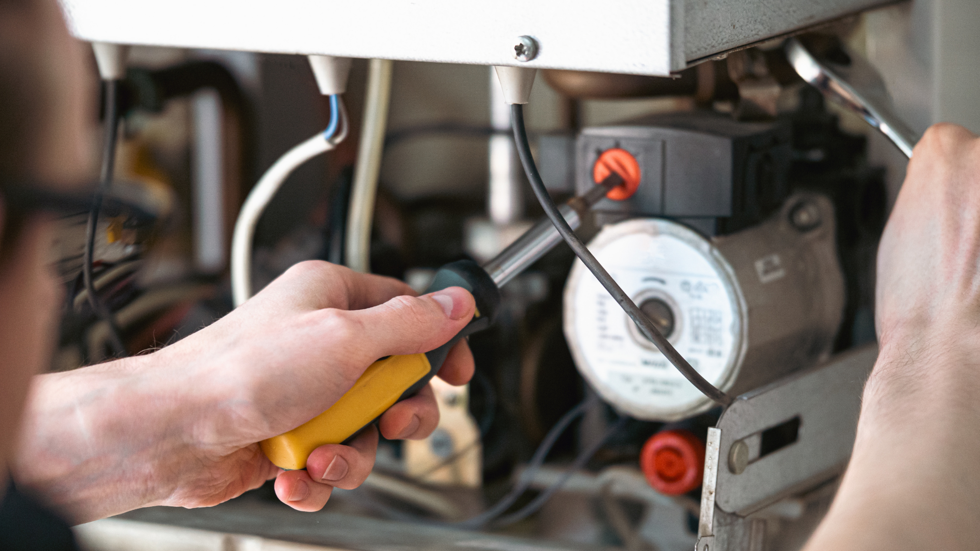 hands using tools on a boiler