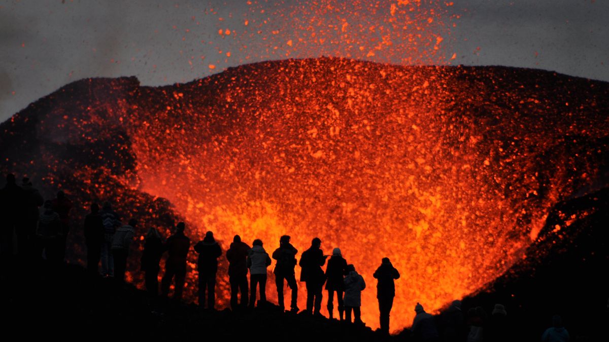 The sillouette of group of adventurers witnessing the eruption of volcano Eyjafjallajökull right up close