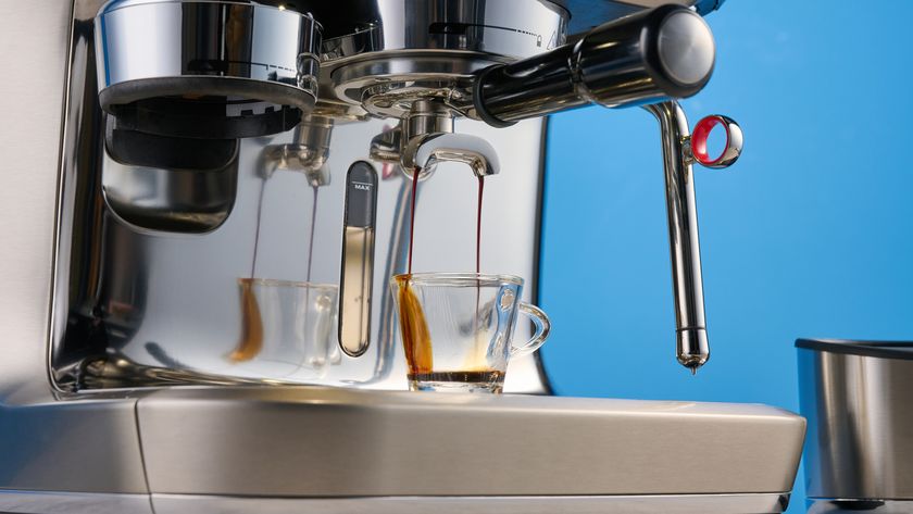 the breville oracle dual boiler / sage oracle dual boiler in stainless steel, showing its touchscreen, steam wand, built in grinder, and espresso shots