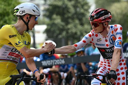 UAE Team Emirates - XRG's Slovenian rider Tadej Pogacar wearing the overall leader's yellow jersey (L) speaks with Team Visma | Lease a Bike's Danish rider Jonas Vingegaard wearing the climber's dotted "King of the Mountains" jersey at the start of the 14th stage of the 113th edition of the Tour de France cycling race, 155,3 km between Mulhouse and Le Markstein in the Vosges mountains, on July 18, 2026. (Photo by Jeff PACHOUD / AFP via Getty Images)