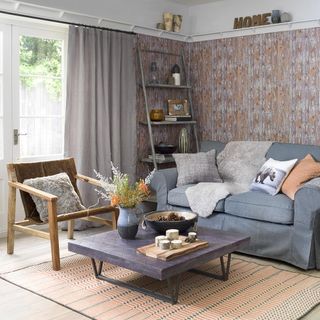 living room with wallpaper and blue sofa