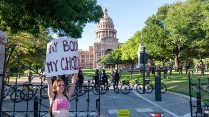 A woman protests at the Texas capitol