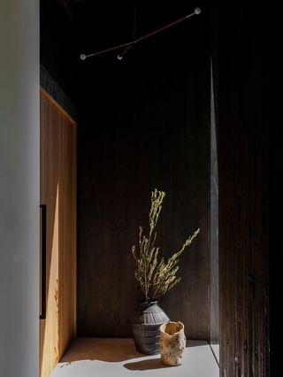 A dark, wood panelled hallway leading into a front door.