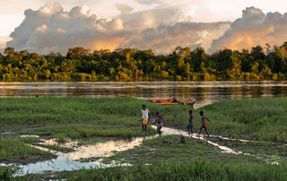 Children play on the river bank, near the village in New Guinea, Indonesia.