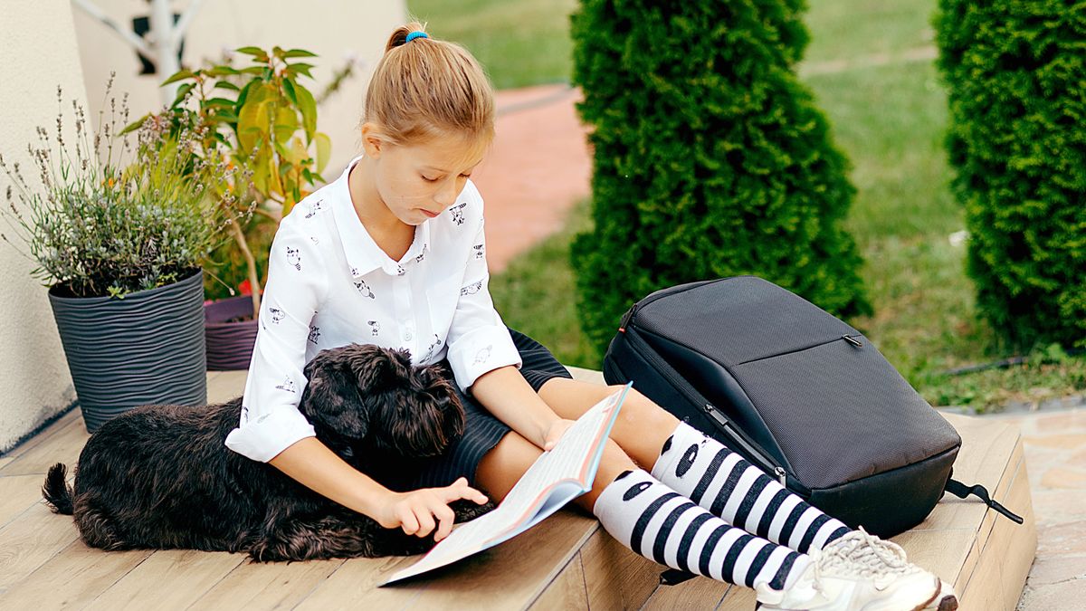 School girl sitting on steps with dog