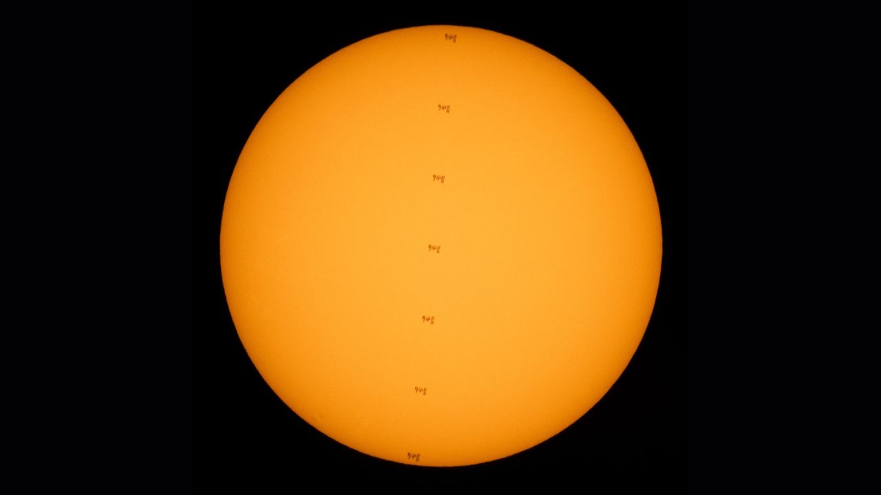 NASA photographer captured this stunning series of photos of the International Space Station crossing the face of the sun while two astronauts worked outside the outpost on July 25, 2021.
