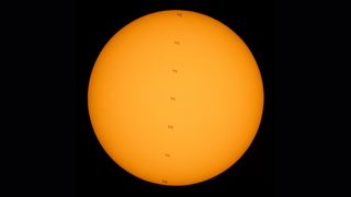 NASA photographer captured this stunning series of photos of the International Space Station crossing the face of the sun while two astronauts worked outside the outpost on July 25, 2021.