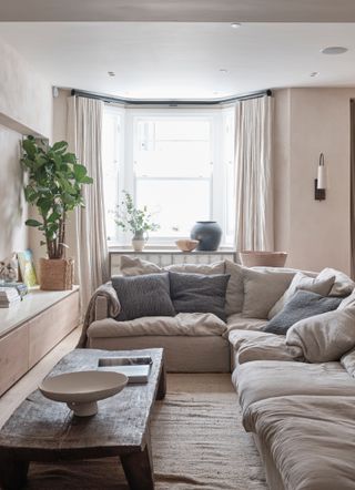 Slouchy corner sofa in a small living room with organic wood coffee table