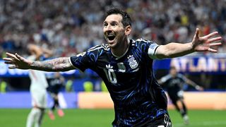 Lionel Messi, wearing dark blue and with his arms outstretched, celebrates Argentina beating England at the World Cup 2026