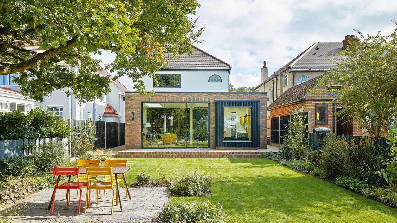 Adding more space the exterior rear of a house with garden and a wraparound extension and sliding doors