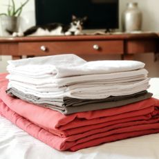 Pile of red, grey and white folded bedsheets