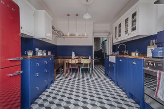 blue galley kitchen with dining table