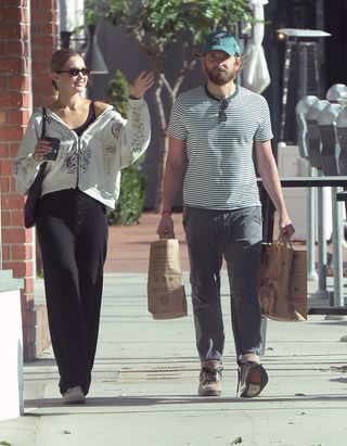 A photo of Gigi Hadid and Bradley Cooper walking together outside Erewhon grocery store