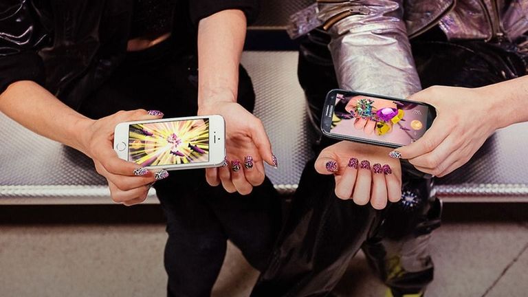 People holding mobile phone with new 3D Hologram App showing manicures