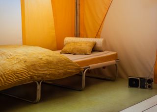 Camping bed with orange mattress