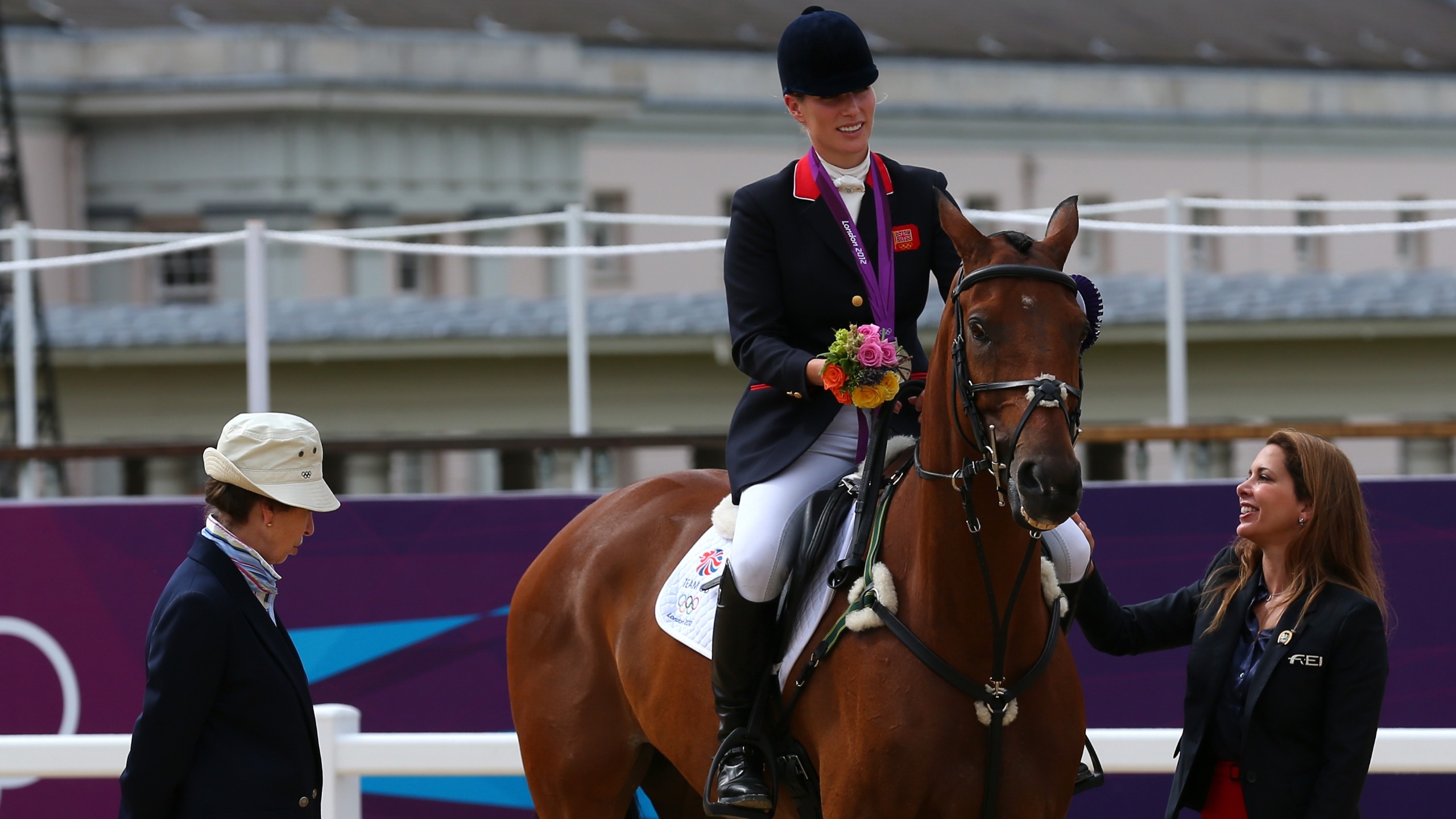 Zara Tindall, sitting on a horse, speaks to her mother Princess Anne after receiving a silver medal on Day 4 of the London 2012 Olympic Games