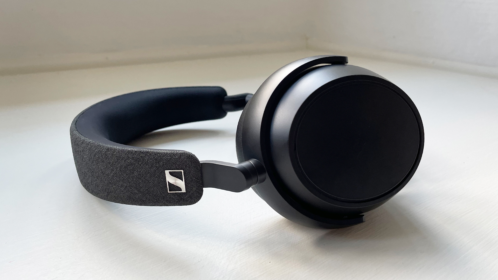 Sennheiser Momentum 4 Wireless in black on a window seat at reviewer's home