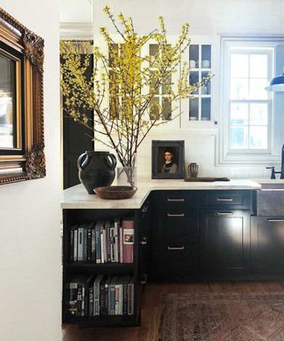 kitchen with black cabinets and display of branches