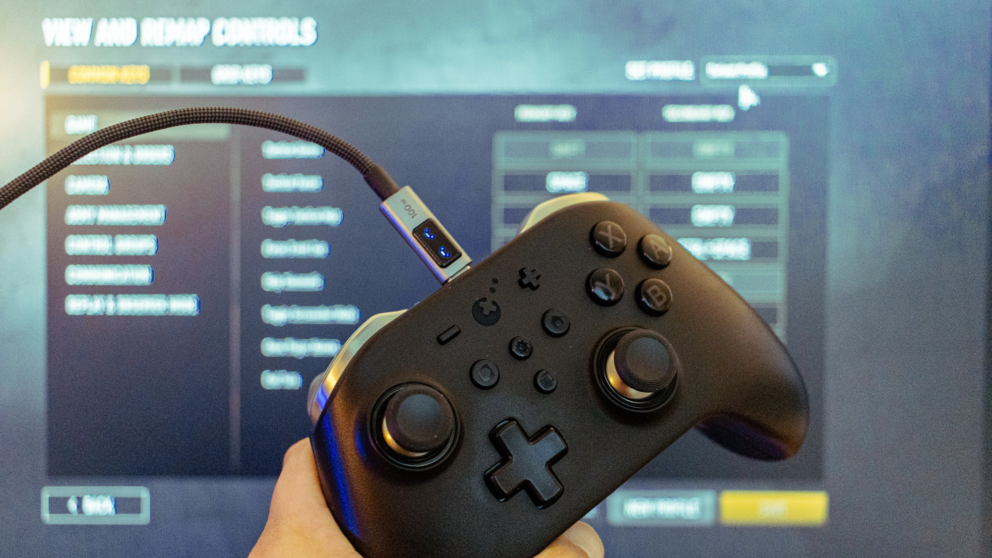 The GuliKit KingKong 2 Pro Controller in front of the settings menu of Company of Heroes 3