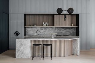 a modern kitchen with an island with a corner taken off