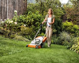 woman mowing lawn with stihl lawn mower