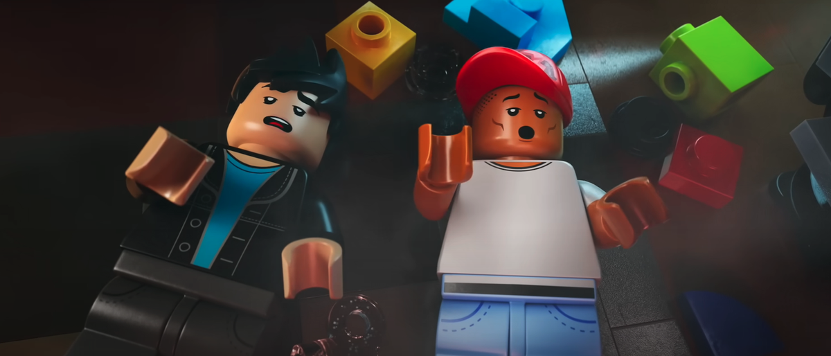 LEGO versions of Chad Hugo and Pharrell Williams on the floor of studio with LEGO pieces around them in Piece By Piece