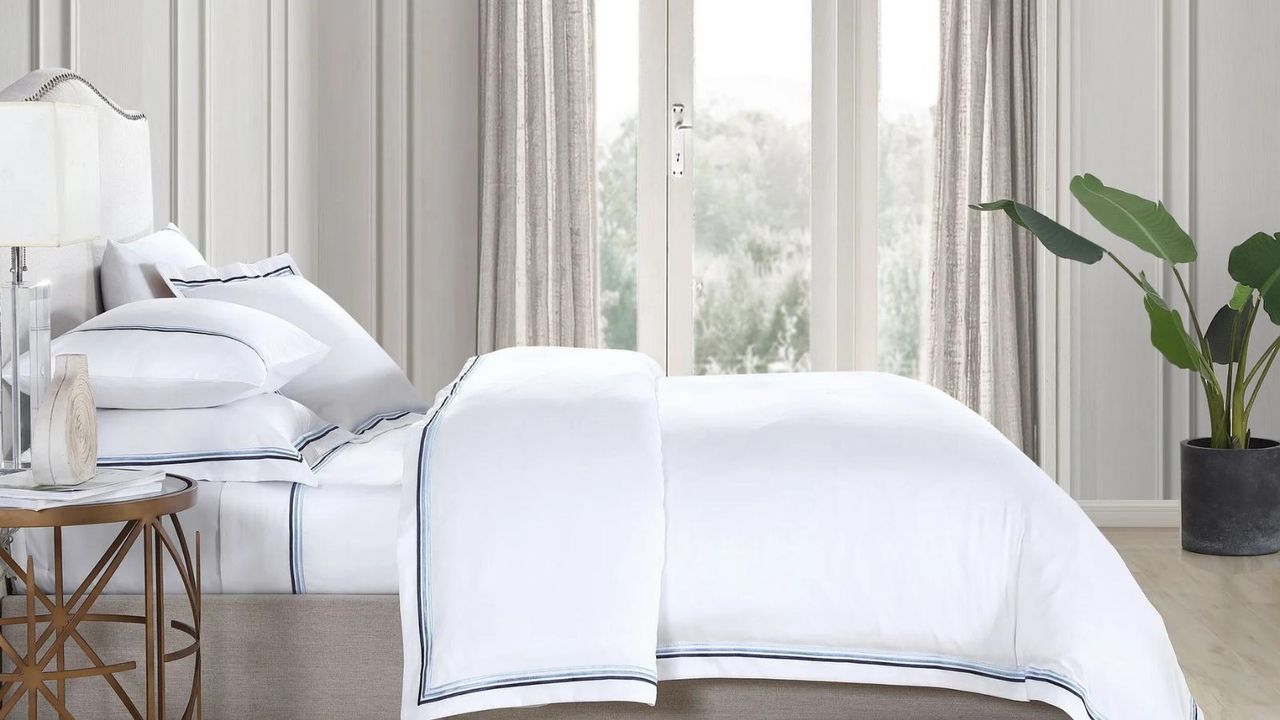 A few of the items in the bedding sales: Triple Luxe Sateen Sheet Set on a bed.