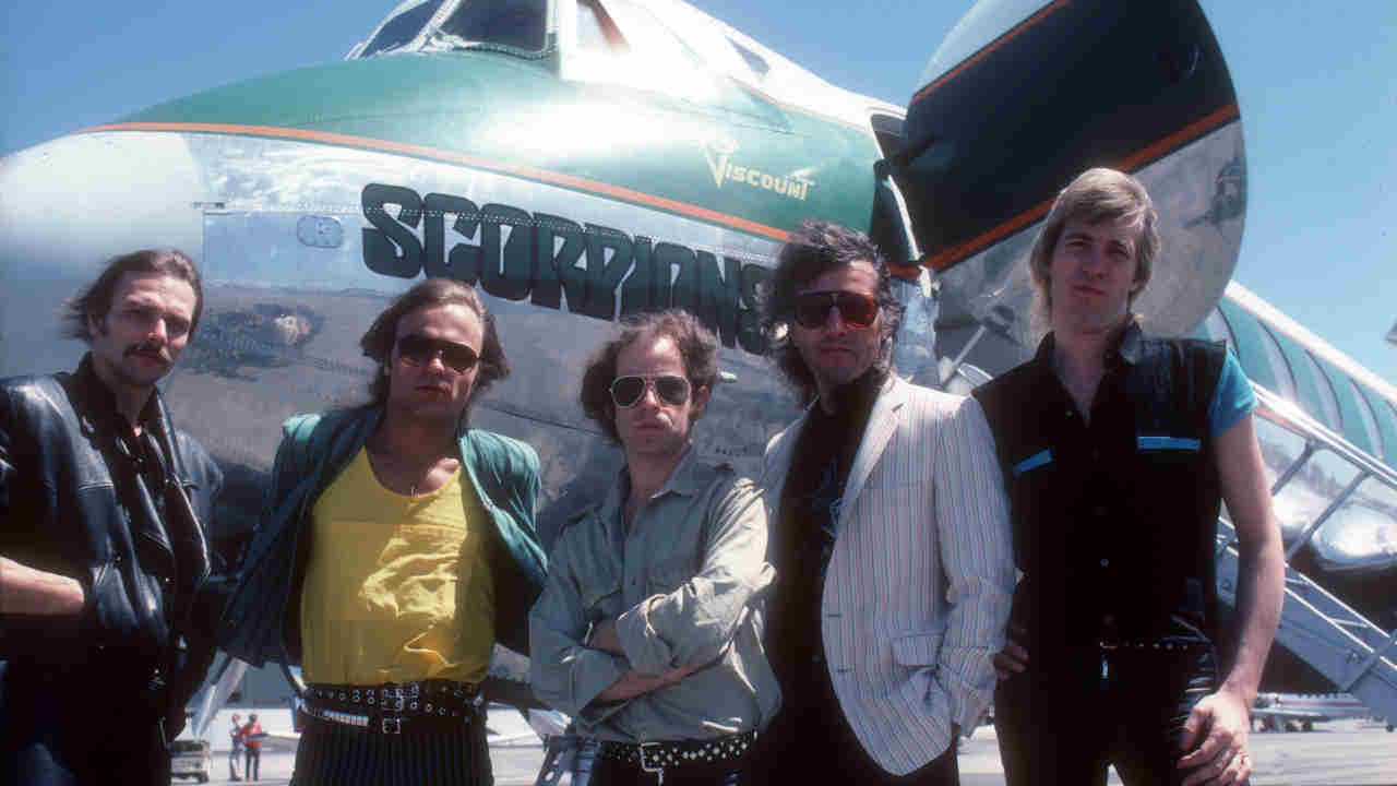 Scorpions posing for a photograph in front of a private jet in the early 1980s