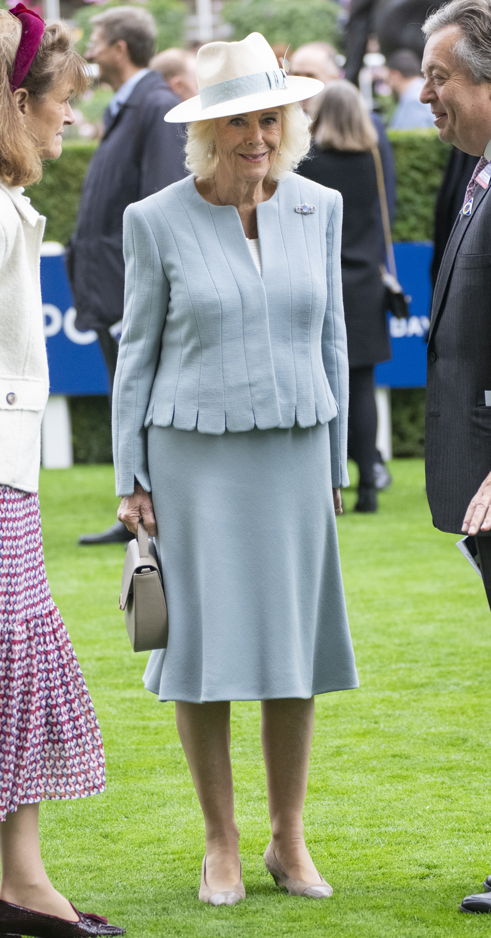 Queen Camilla wearing a light blue skirt suit and hat