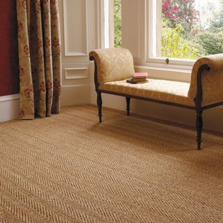 best carpet colour for living room, living room with terracotta coloured natural carpet, herringbone style design, antique chaise, patterned curtains, red walls