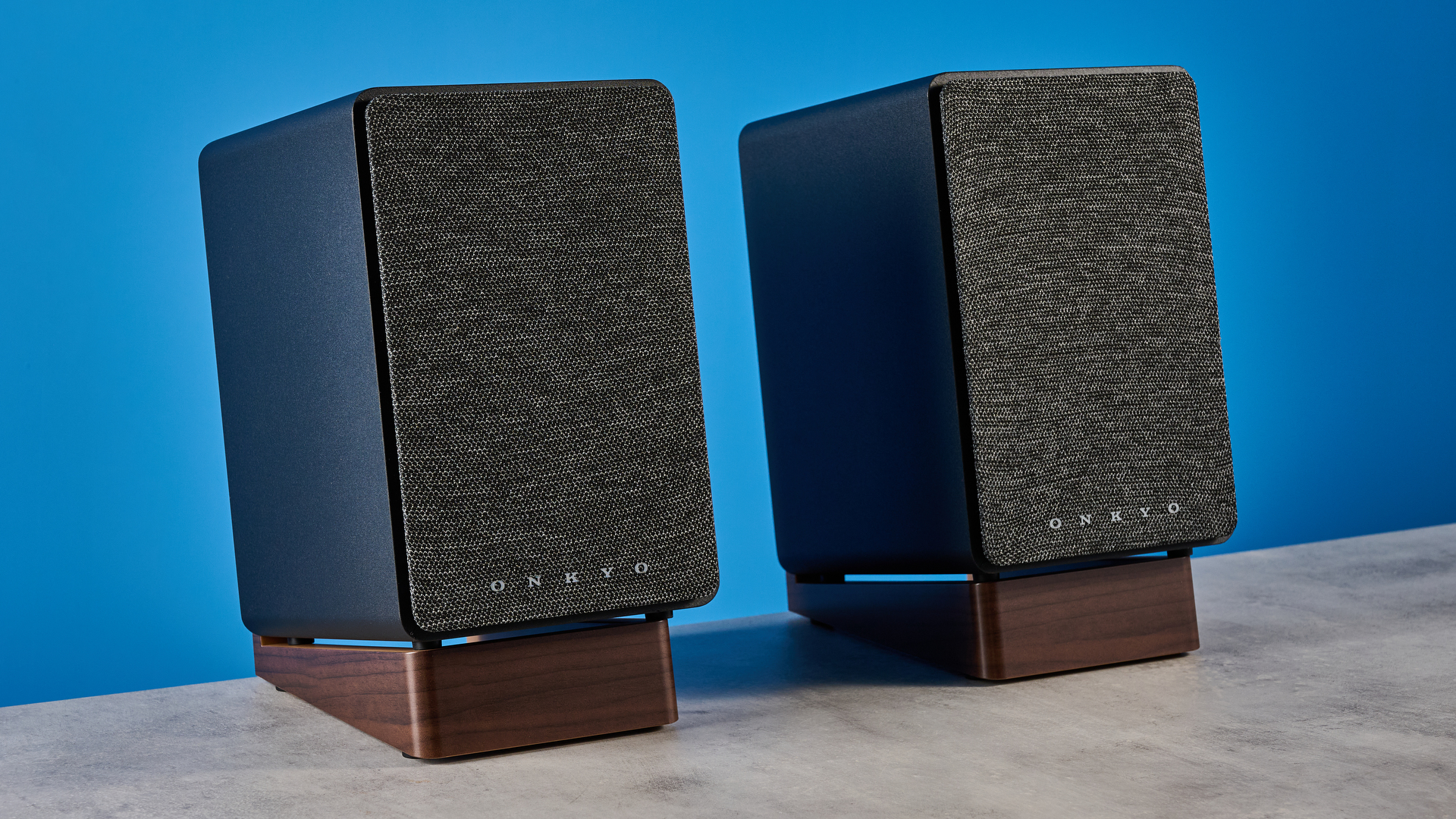 Onkyo GX-30ARC bookshelf speakers photographed on a blue background