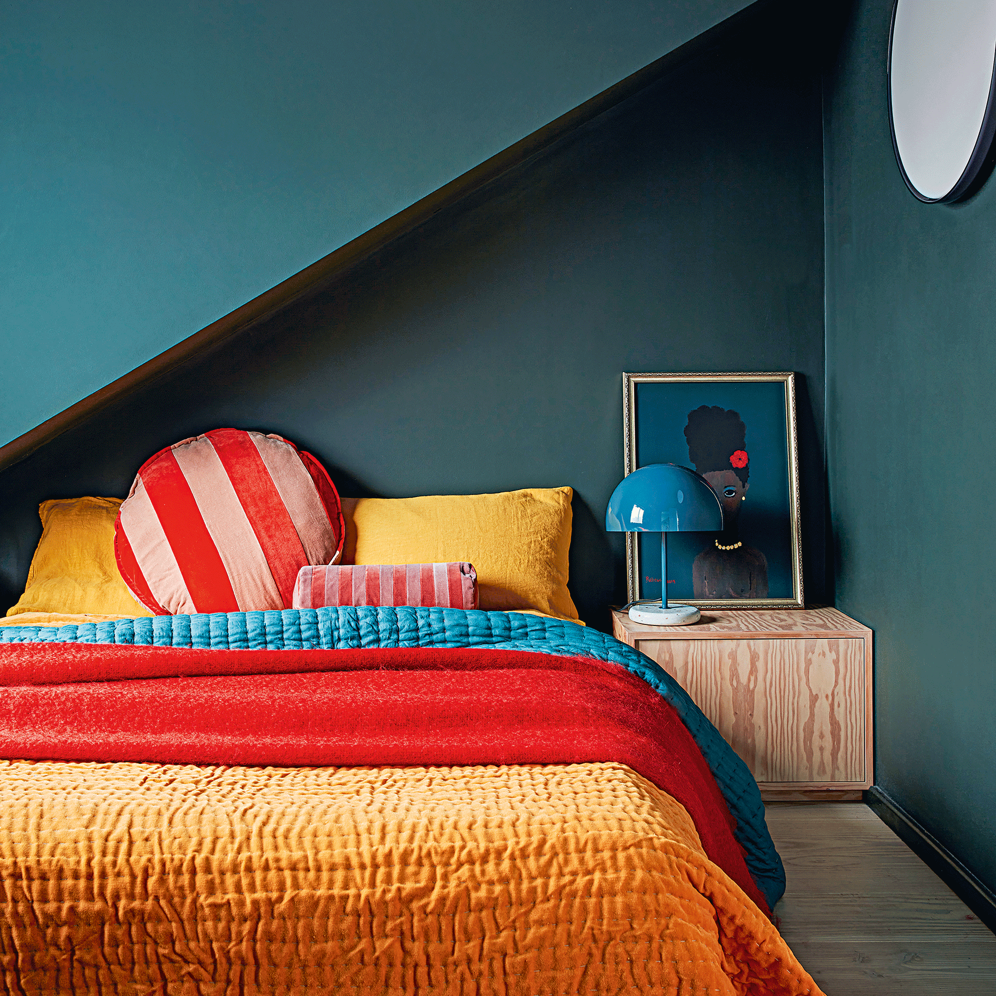Navy blue bedroom with bed with yellow, blue and red bedding
