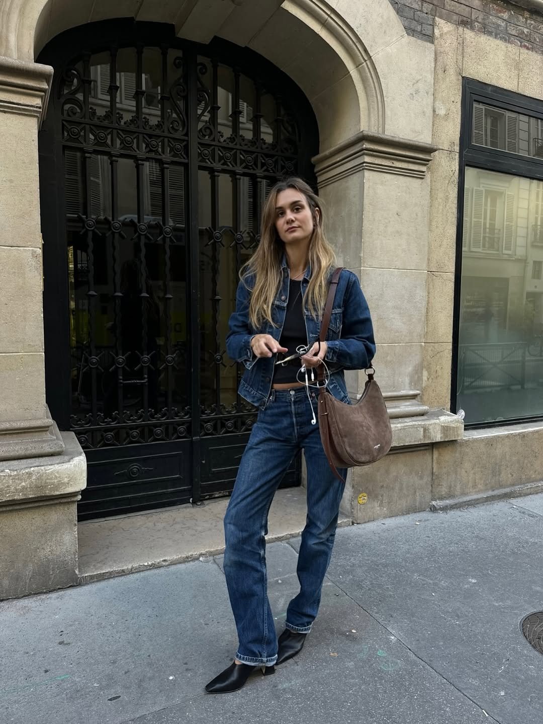 Influencer Anne Lauremais wearing a denim jacket, straight-leg jeans and mules.