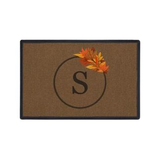 A brown fall doormat with a circle that says 'S' and leaves around it