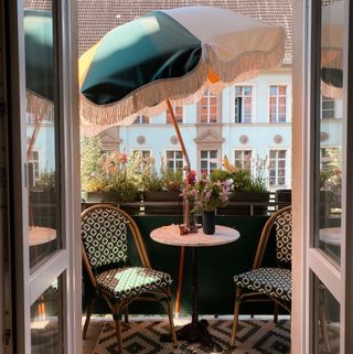 Small balcony with bistro set and large sun umbrella