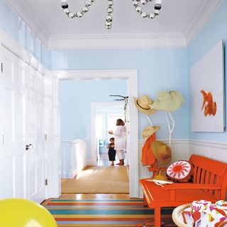hallway with woode floor and blue wall and orange bench