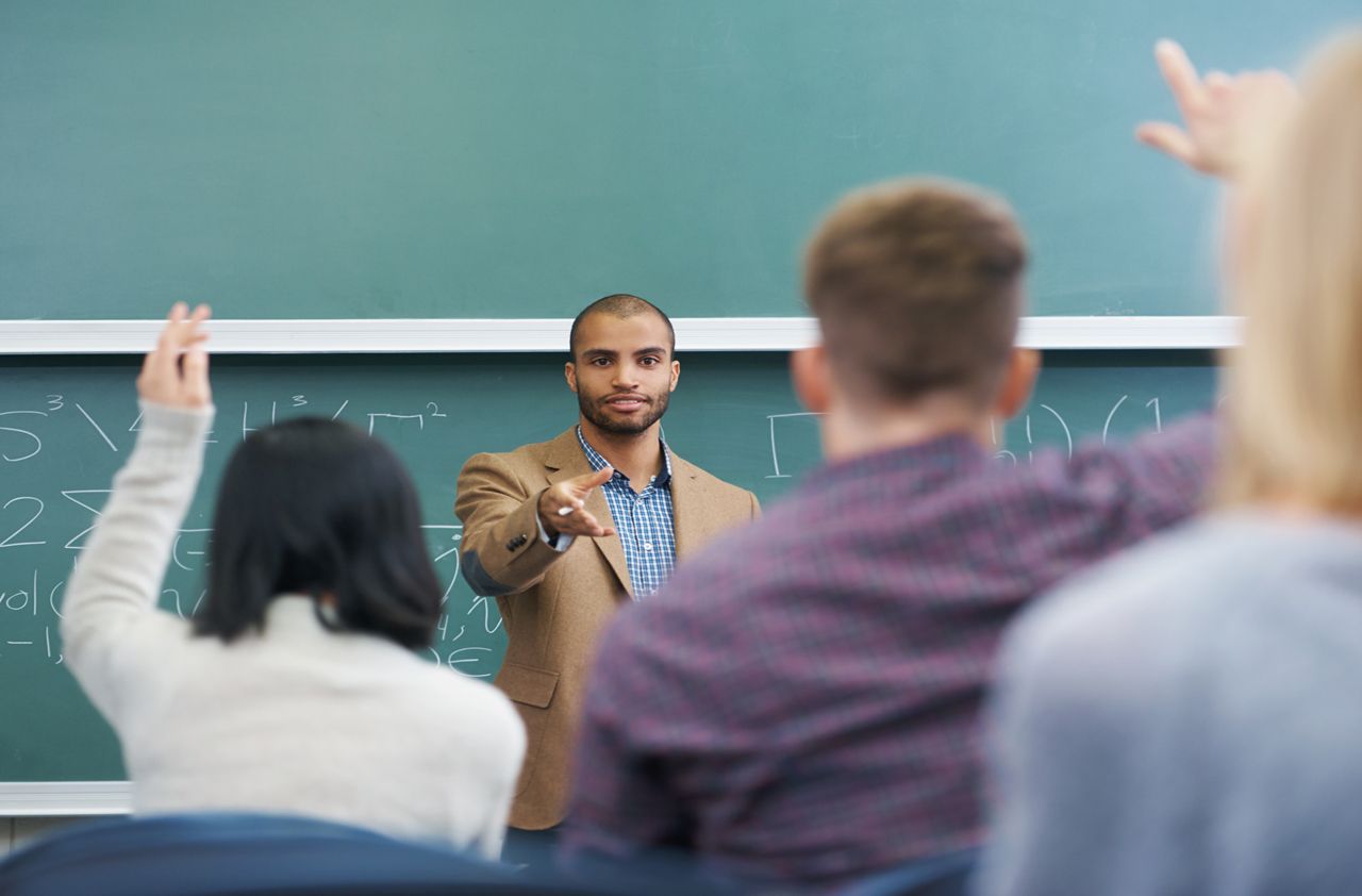 Shot of a young male teacher giving a lesson to his students on the lecture hall