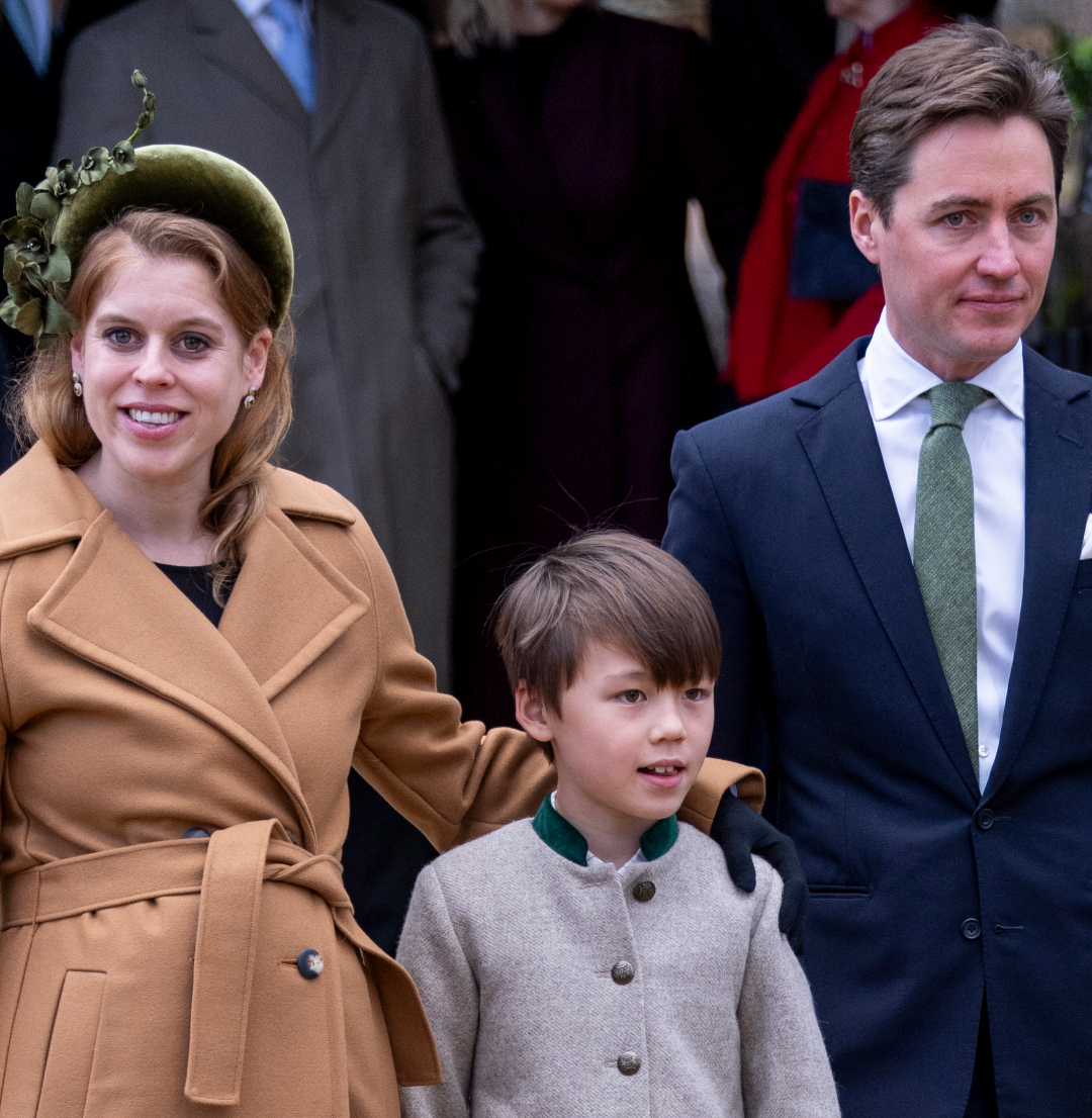 Princess Beatrice wearing a tan coat standing with her arm around her stepson, standing next to Edoardo Mapelli Mozzi