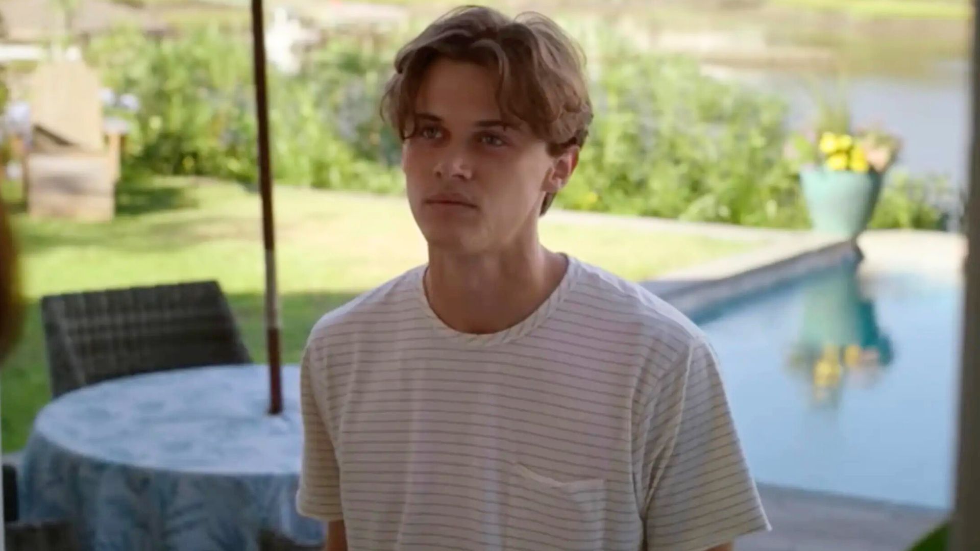 Conrad looks on in a back garden by a pool