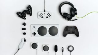 The Xbox Accessibility Ecosystem laying flat on a white background. Includes the Xbox Adaptive Controller, standard controller, Adaptive Joystick, accessibility kit, headphones, and additional input devices.