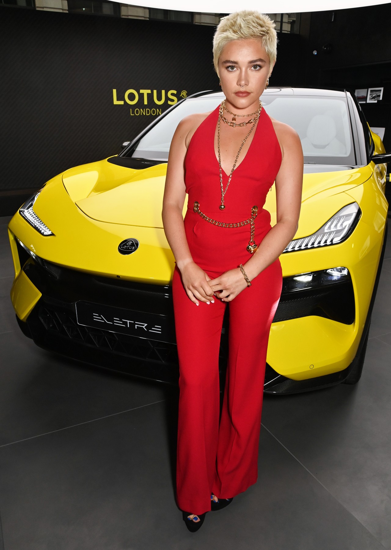 Florence Pugh standing in front of a bright yellow car.
