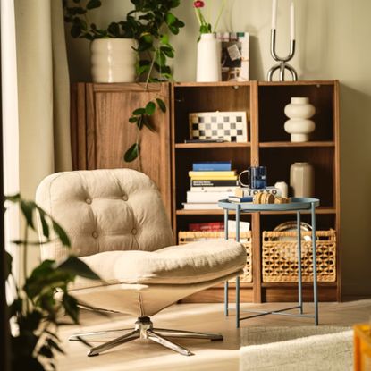 IKEA DYVLINGE Swivel easy chair in beige in a living room with a wooden display cabinet and a blue side table