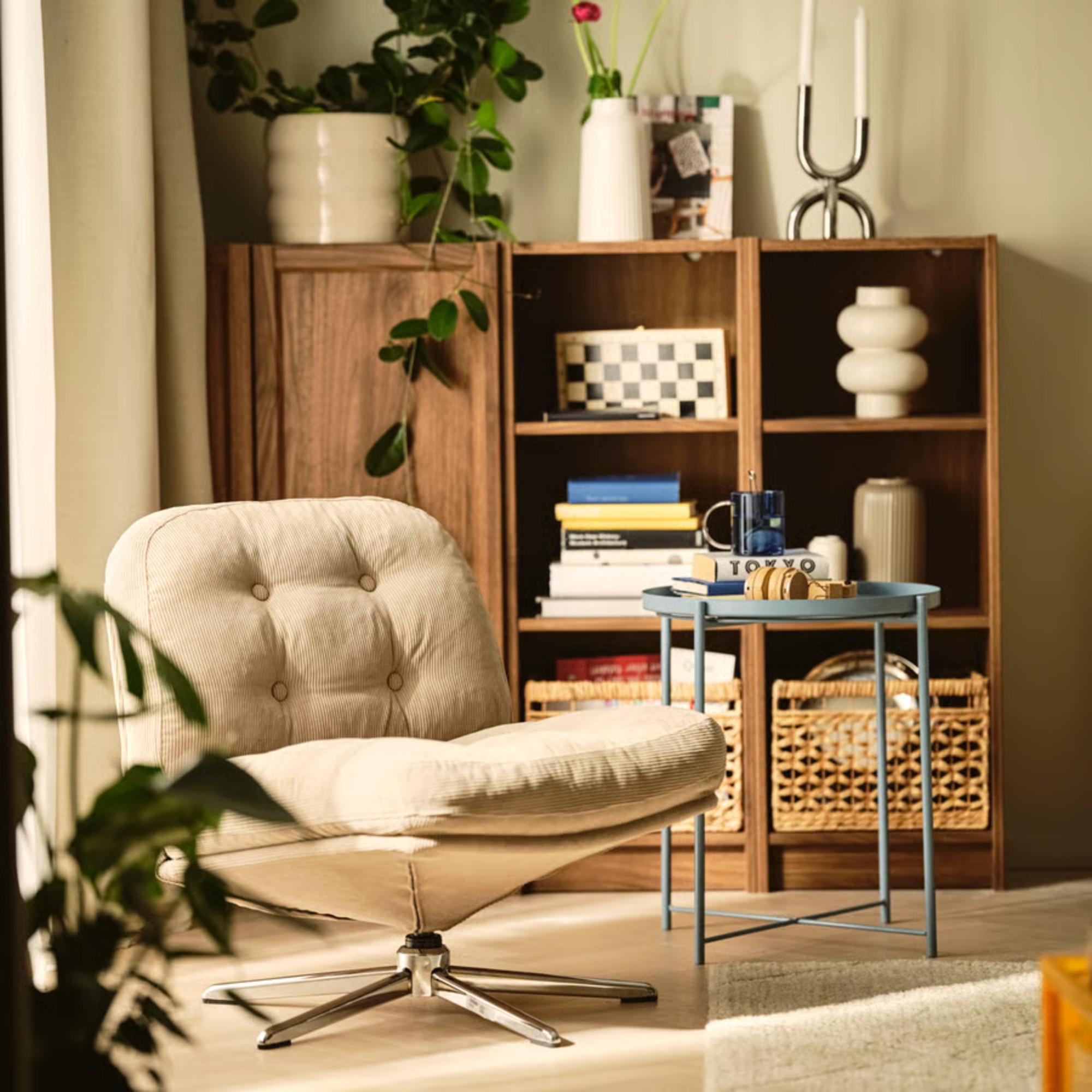 IKEA DYVLINGE Swivel easy chair in beige in a living room with a wooden display cabinet and a blue side table