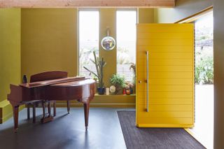 a yellow front door opening into an entrance hall