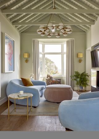 living room with pale blue sofas and pink ottoman