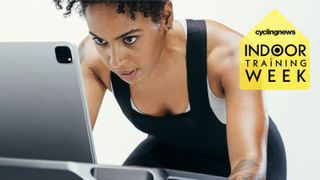 A woman training on a turbo trainer and intensely staring at a laptop, with a yellow badge overlaid that says Indoor Training Week