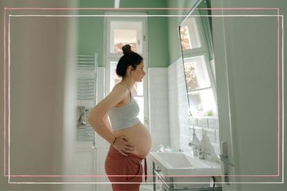 A woman experiencing thrush in pregnancy stands in a bathroom looking in the mirror