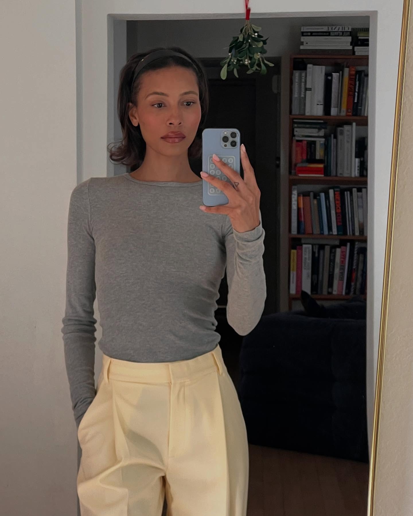 A woman taking a mirror selfie wearing a headband on her bob hairstyle