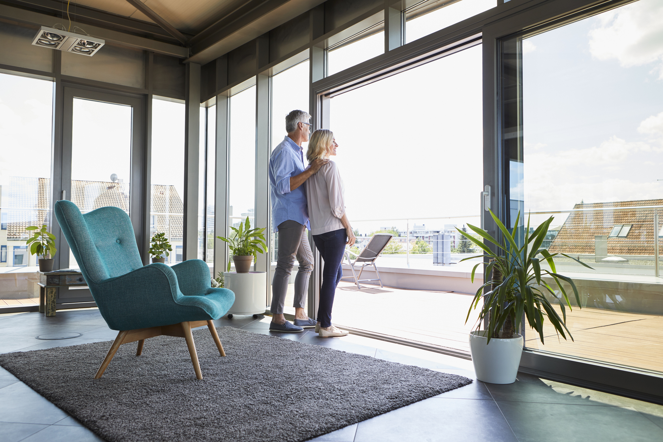 Mature couple looking out of window at home